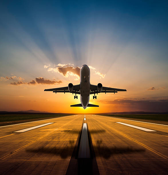 Airplane taking off at sunset
